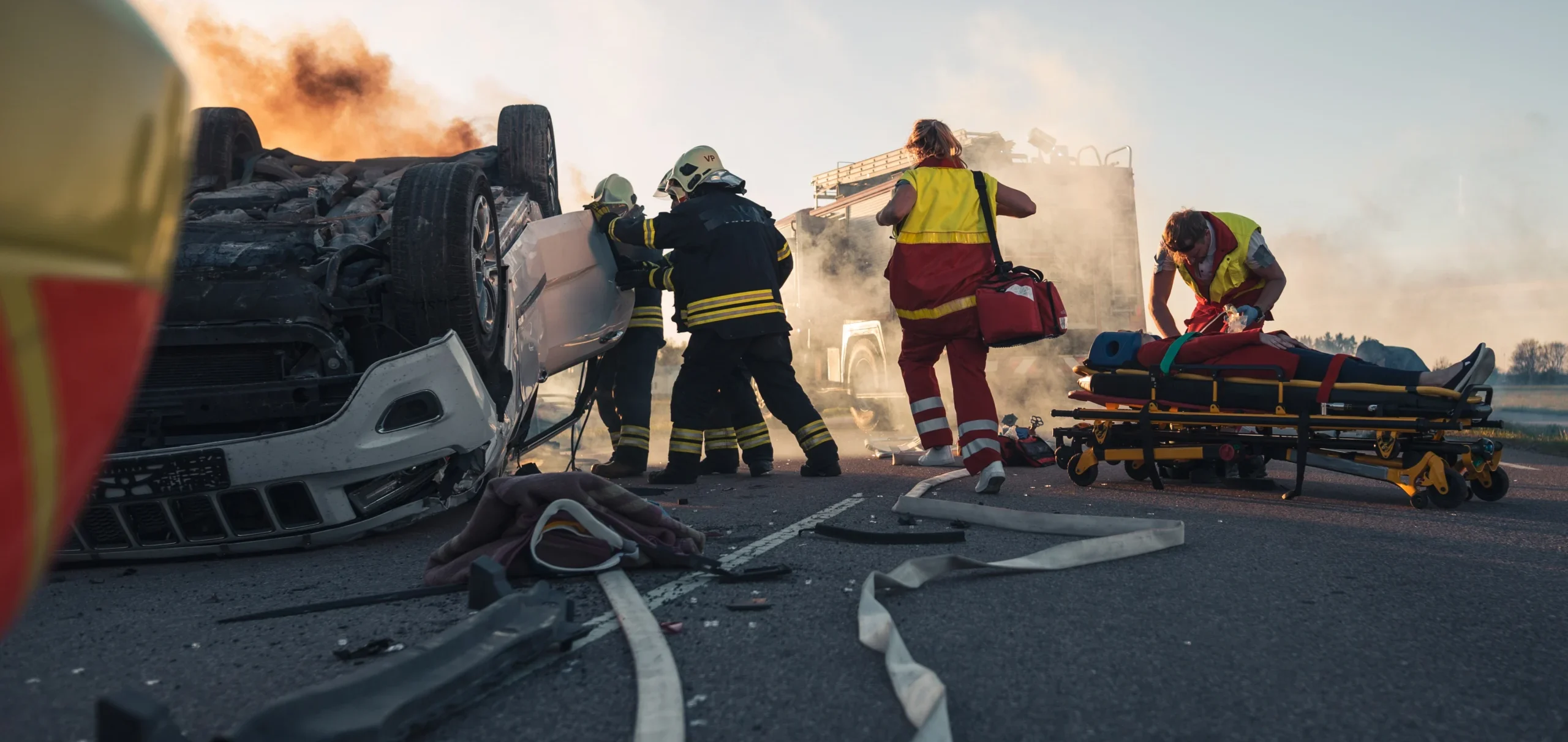 Firefighters pull open the door of a rolled-over car