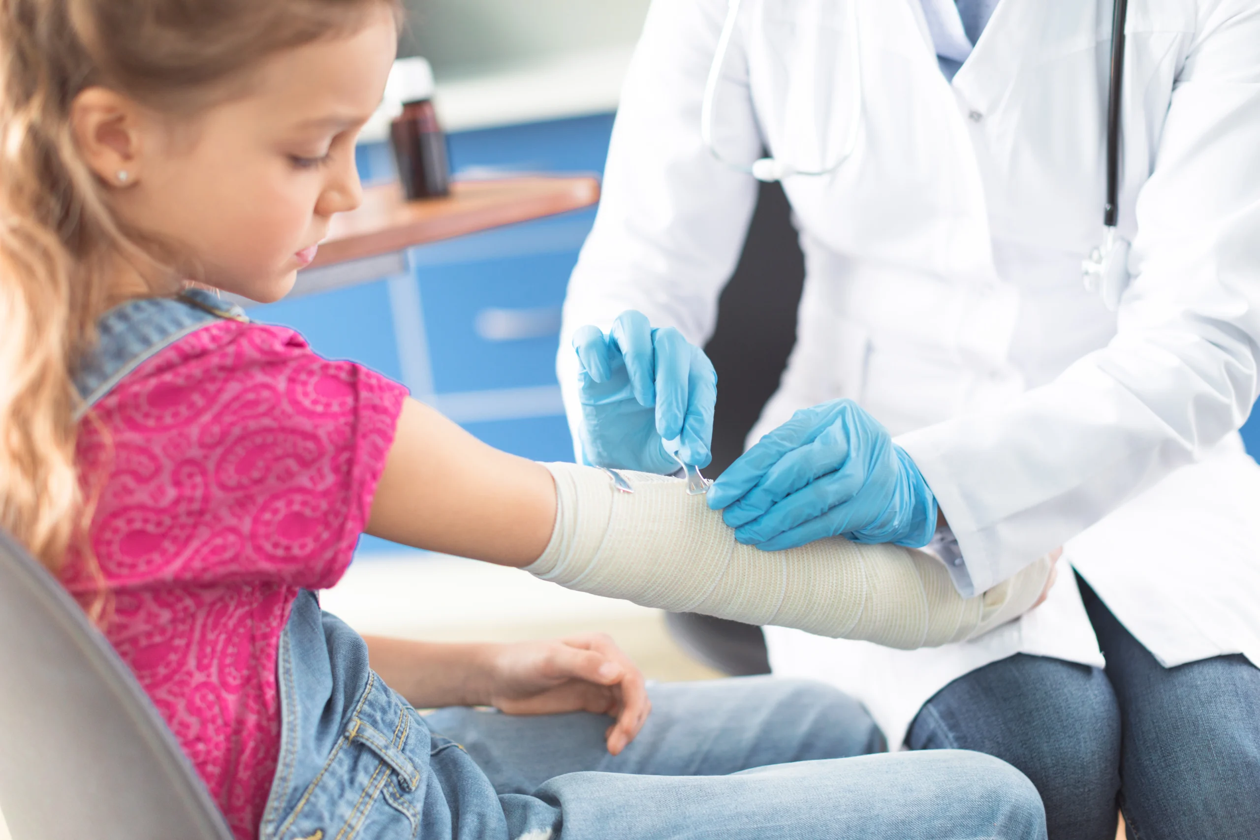 A health professional bandages a child's arm