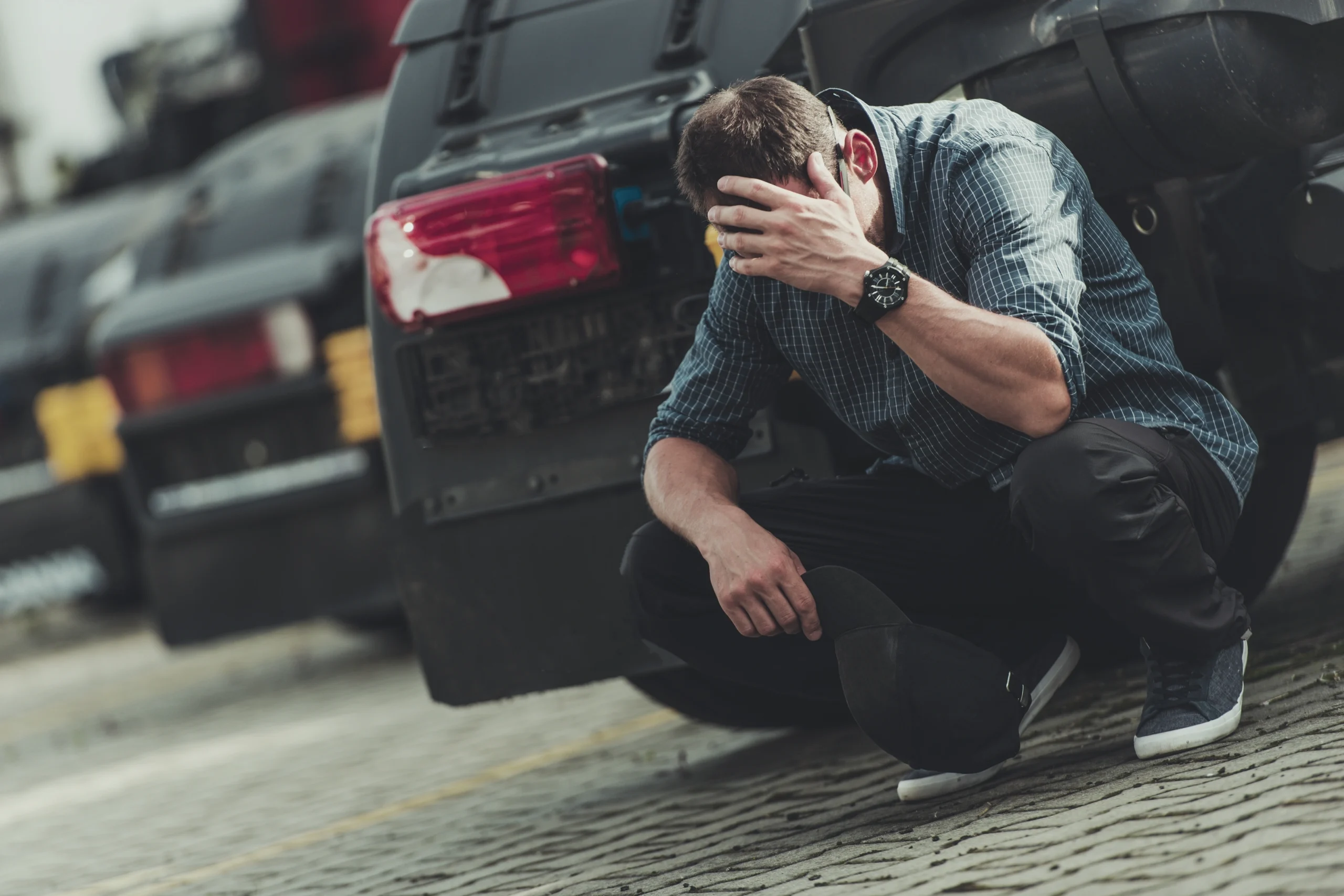 A person holds their head outside of a car accident