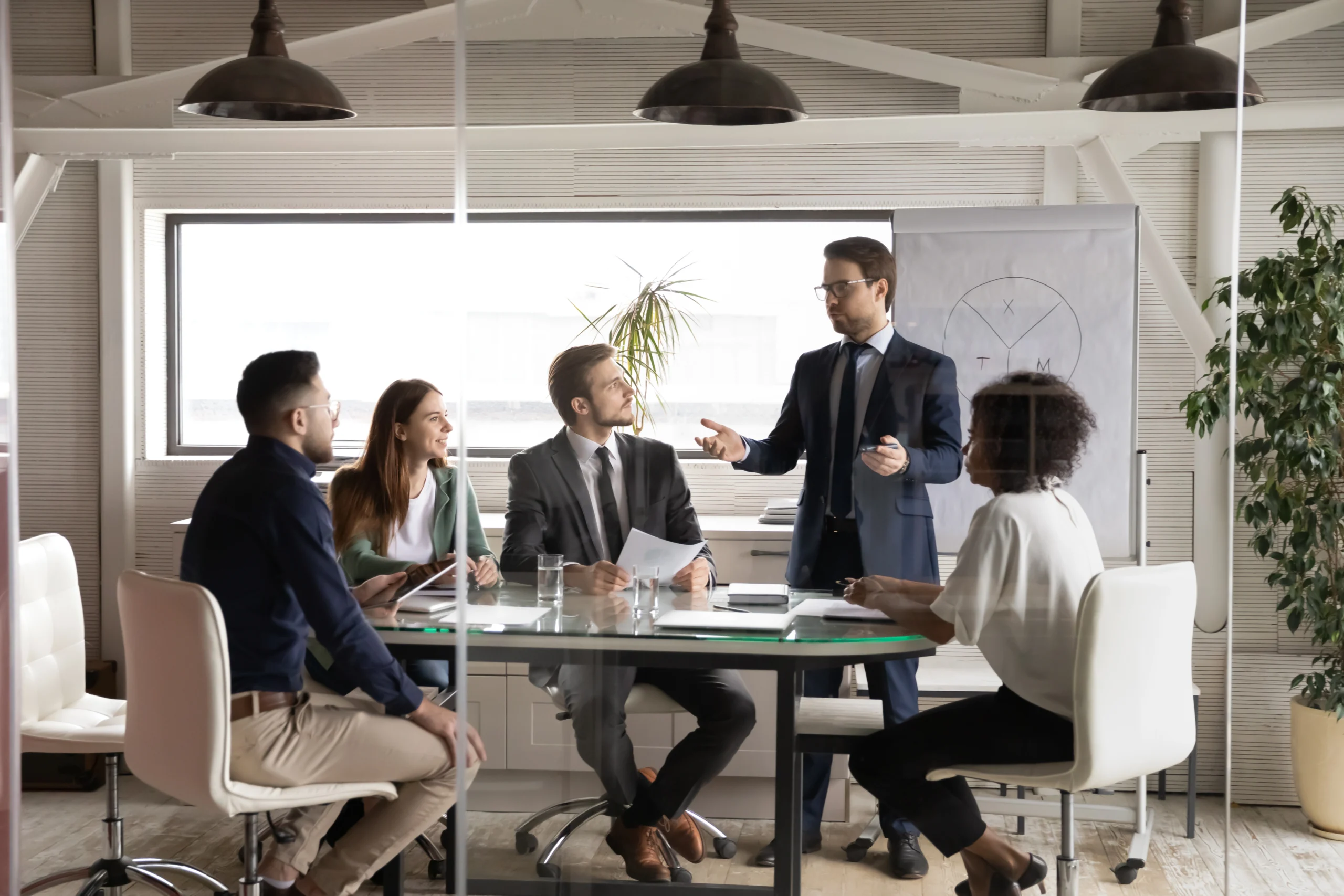 Professionals discuss business at a desk in a board room