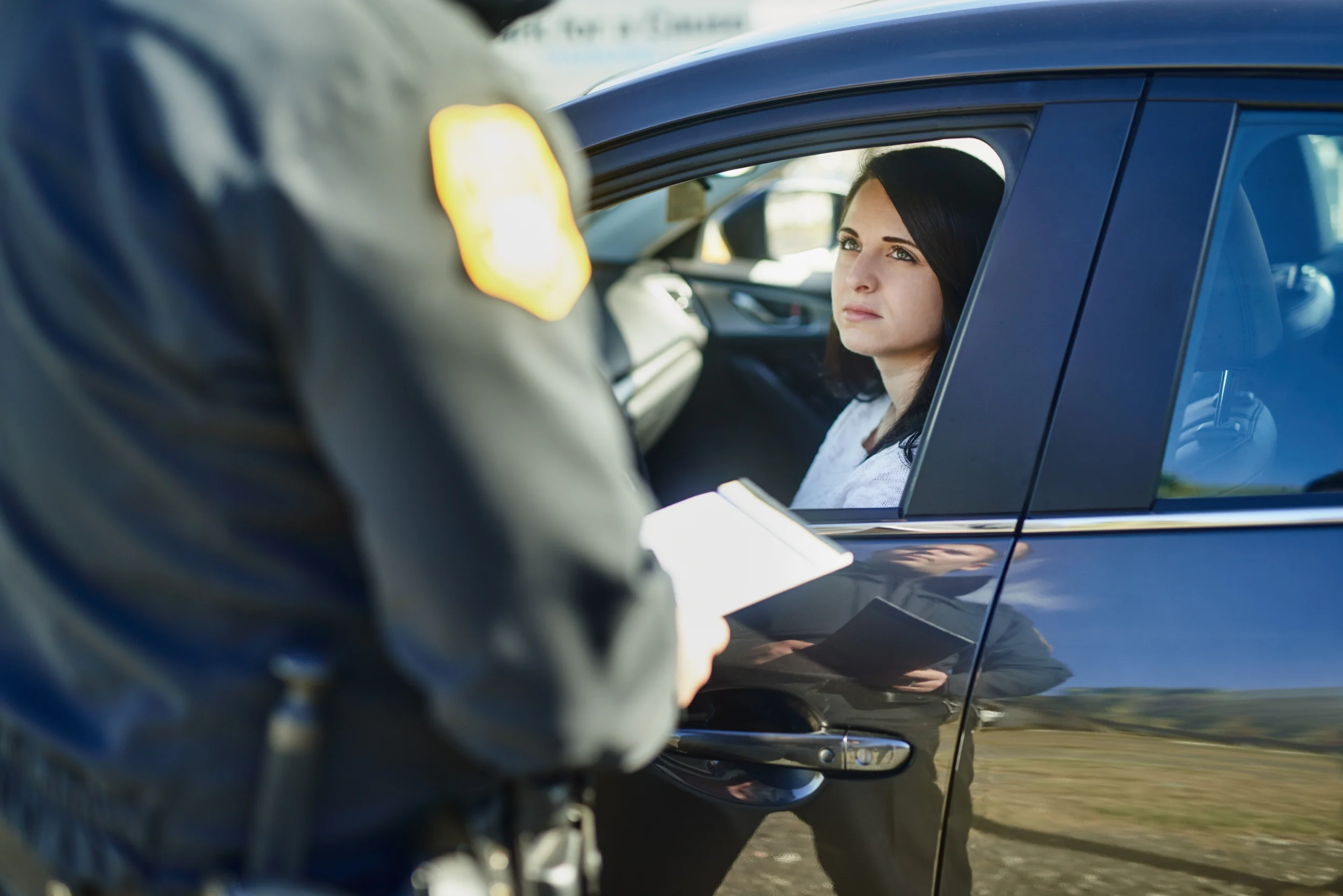 A woman being pulled over listens to an officer
