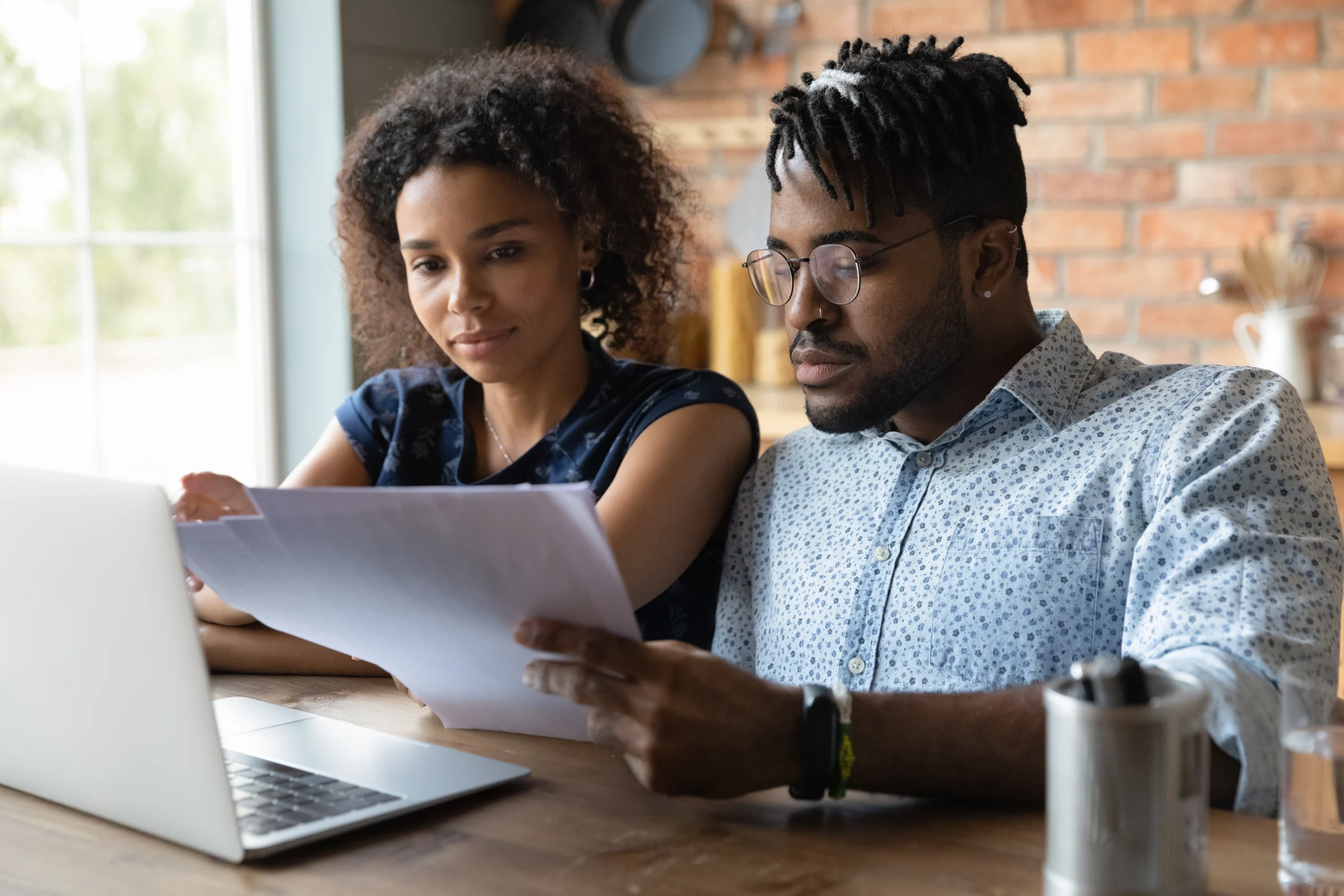 A couple reviews forms in front of a laptop